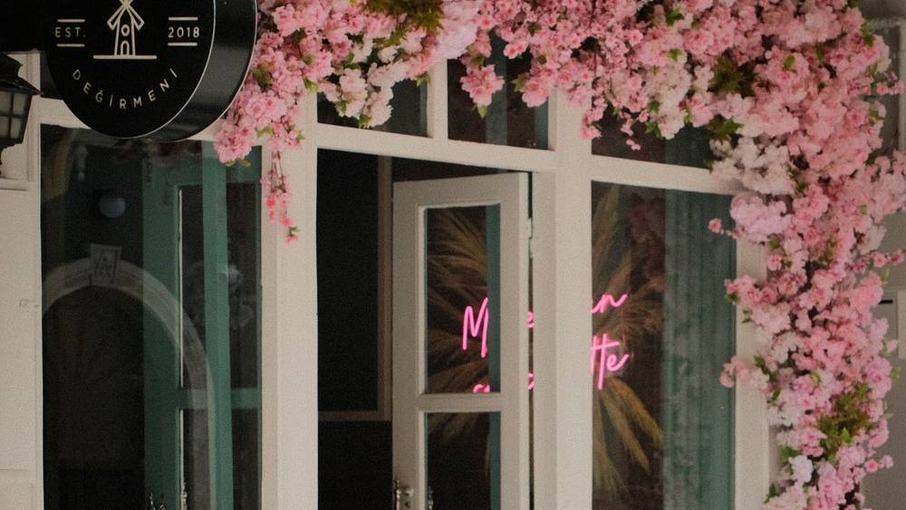 Entrada de cafetería decorada con flores de cerezo