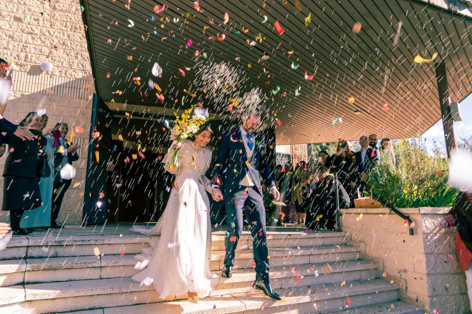 Novios saliendo entre confeti tras la ceremonia