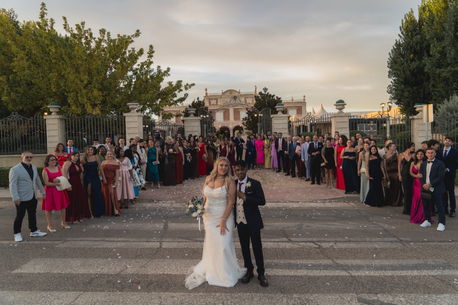 Novios con invitados celebrando frente al palacio