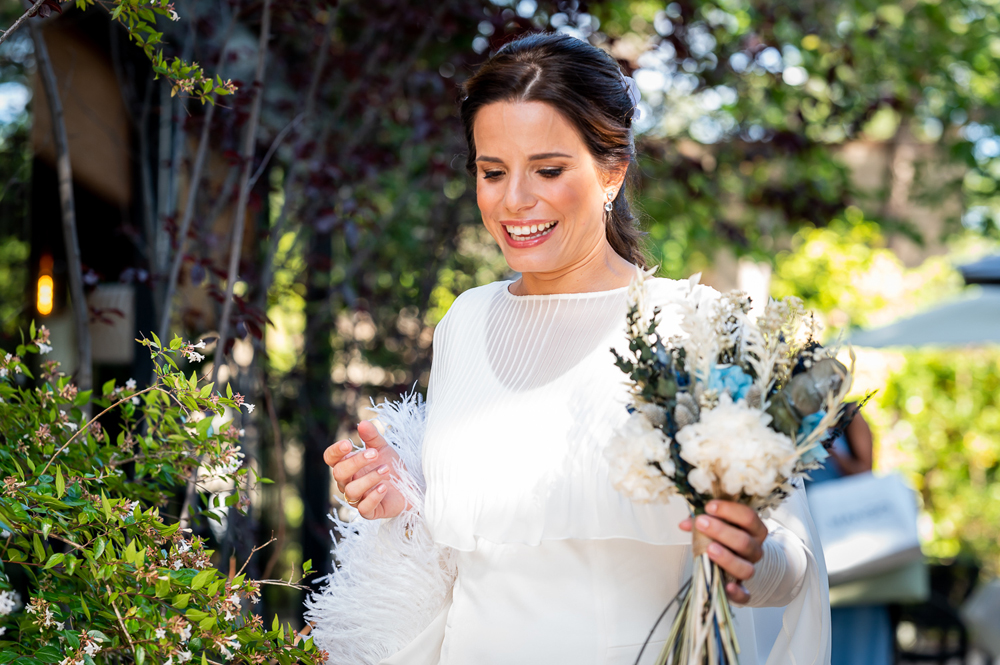 novia feliz con ramo de novia azul y blanco