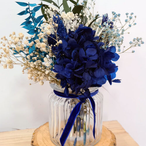 centro de flores azules con base de cristal