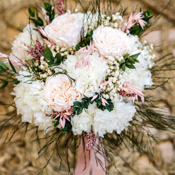 ramo dolce de flores en tonos blancos y un toque de rosa
